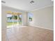 Bright living room features tile flooring, large sliding glass doors, and natural light at 13366 Barkingside Pl, Spring Hill, FL 34609