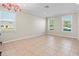 Bright and airy living room with large windows, neutral walls and beautiful tile flooring at 13366 Barkingside Pl, Spring Hill, FL 34609