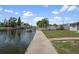 Waterfront property with concrete dock, grassy yard, and a white picket fence for a quaint, tranquil setting at 13700 Allyn Dr, Hudson, FL 34667