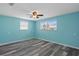 Bright bedroom features wood-look floors, ceiling fan and two windows with lots of natural light at 13700 Allyn Dr, Hudson, FL 34667