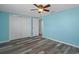 Bedroom showcases wood-look floors, ceiling fan, and closet for ample storage solutions at 13700 Allyn Dr, Hudson, FL 34667