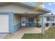 Inviting front porch with seating area, blue column and well maintained lawn and foliage at 13700 Allyn Dr, Hudson, FL 34667