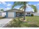 Charming single-story home with blue accents, front lawn, and mature palm tree at 13700 Allyn Dr, Hudson, FL 34667