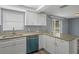 The kitchen includes granite countertops, white cabinets and stainless steel appliances at 13700 Allyn Dr, Hudson, FL 34667