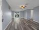 Open concept living room with gray wood floors, sliding glass doors, and a ceiling fan at 13700 Allyn Dr, Hudson, FL 34667