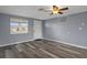Living room with gray wood floors, window and a white door at 13700 Allyn Dr, Hudson, FL 34667