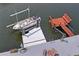 Aerial shot of a boat in boat lift next to a waterfront with mosaic table and chairs at 15635 Bertram Dr, Hudson, FL 34667