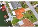 Aerial view of a waterfront home boasting a vibrant orange tile roof, lush landscaping, and a private boat dock at 15635 Bertram Dr, Hudson, FL 34667