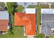 Bird's eye view of a waterfront property featuring a red tile roof, lush green lawn, and mature trees in a canal community at 15635 Bertram Dr, Hudson, FL 34667