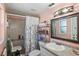 Bathroom featuring granite countertop, framed mirror, and tiled walk-in shower with seat at 15635 Bertram Dr, Hudson, FL 34667