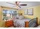 Comfortable bedroom with iron bed, wood floors, and natural light from the window at 15635 Bertram Dr, Hudson, FL 34667