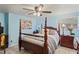 Spacious bedroom with four-poster bed, ceiling fan, and wood-look floors at 15635 Bertram Dr, Hudson, FL 34667
