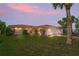 Enchanting single-story home with tile roof and a well-manicured lawn as the sun sets at 15635 Bertram Dr, Hudson, FL 34667