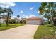 Cozy single-story home featuring a tile roof, an attached two-car garage, and a well-maintained front lawn at 15635 Bertram Dr, Hudson, FL 34667