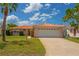 Charming single-story home with a well-manicured lawn, tile roof, and a two-car garage at 15635 Bertram Dr, Hudson, FL 34667