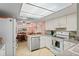 Well-lit kitchen with white cabinets, an island, modern appliances, and an adjoining dining area at 15635 Bertram Dr, Hudson, FL 34667
