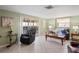 Relaxing living room with tile floors, comfortable seating, and access to a screened-in patio with outdoor furniture at 15635 Bertram Dr, Hudson, FL 34667