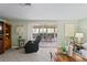Spacious living room featuring tile floors, comfortable seating, and glass sliding door access to the screened-in patio at 15635 Bertram Dr, Hudson, FL 34667