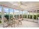 Bright sunroom with tile floors, neutral decor, surrounding windows, and a ceiling fan at 15635 Bertram Dr, Hudson, FL 34667