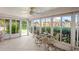 View of cozy sunroom featuring tile floors, ceiling fan, and surrounding windows offering backyard view at 15635 Bertram Dr, Hudson, FL 34667