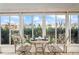 Close-up of sunroom seating area with tiled floor and surrounding windows offering outdoor view at 15635 Bertram Dr, Hudson, FL 34667