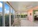 Cozy sunroom featuring tile floors, a ceiling fan, and surrounding windows with outdoor scenery at 15635 Bertram Dr, Hudson, FL 34667