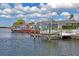 Waterfront property with boat lifts, and seating, under a blue sky with fluffy clouds at 15635 Bertram Dr, Hudson, FL 34667