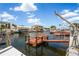 Scenic waterfront featuring a dock, boat lift, seating, and a picturesque canal view at 15635 Bertram Dr, Hudson, FL 34667