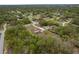 A lush community with mature trees surrounds a home with long driveway and large screened in back porch at 18216 Monteverde Dr, Spring Hill, FL 34610