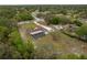 A quaint home with long driveway and screened in back porch with mature green trees surrounding the property at 18216 Monteverde Dr, Spring Hill, FL 34610