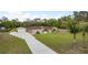 Spacious single-story home with detached garage, featuring a long driveway and well-manicured lawn at 18216 Monteverde Dr, Spring Hill, FL 34610
