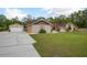 Inviting single-story home with a detached garage, set on a well-maintained lawn with mature trees at 18216 Monteverde Dr, Spring Hill, FL 34610