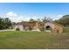 Charming single-story home featuring stucco exterior with stone accents, well-maintained lawn, and mature landscaping at 18216 Monteverde Dr, Spring Hill, FL 34610