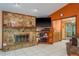 Stone fireplace and built-ins create a warm focal point in the tiled living room with an orange accent wall at 18216 Monteverde Dr, Spring Hill, FL 34610