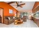 Inviting living room with neutral tile flooring, a ceiling fan, and sliding glass doors to the backyard at 18216 Monteverde Dr, Spring Hill, FL 34610
