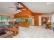 Bright, open living room features tile flooring, a ceiling fan, and a breakfast bar with barstool seating at 18216 Monteverde Dr, Spring Hill, FL 34610
