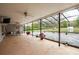 Large screened patio with ample space for outdoor seating, ceiling fans, and a view of the green backyard at 18216 Monteverde Dr, Spring Hill, FL 34610