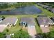 Aerial view of the home showcasing the landscaping, lake view, and neighborhood at 19879 Tattnall Way, Brooksville, FL 34601