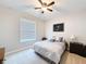 Bright bedroom features a cozy bed, ceiling fan, bedside table, and a window that lets in natural light at 19879 Tattnall Way, Brooksville, FL 34601