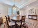 Charming dining room featuring a rustic chandelier and views to the front entrance at 19879 Tattnall Way, Brooksville, FL 34601