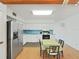 Bright eat-in kitchen featuring stainless steel appliances, white cabinets, and wood flooring at 2221 Swedish Dr # 15, Clearwater, FL 33763