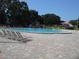 Expansive community pool surrounded by lounge chairs and lush trees, offering a resort-like experience at 2221 Swedish Dr # 15, Clearwater, FL 33763
