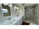 Bathroom featuring dual sinks, a granite countertop, and a walk-in shower at 3415 Holly Springs Dr, Hernando Beach, FL 34607