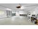 Spacious garage with concrete floor, storage shelves, work bench, and natural light at 3415 Holly Springs Dr, Hernando Beach, FL 34607