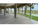 Underneath the house showing support columns, stairs, and a waterfront view at 3415 Holly Springs Dr, Hernando Beach, FL 34607