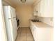 Efficient kitchen includes a refrigerator, stove, and plenty of white cabinets at 4217 Terrapin Pl # 4217, New Port Richey, FL 34652