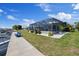 Beautiful backyard featuring a screened lanai, waterfront views, and lush landscaping at 4400 Floramar Ter, New Port Richey, FL 34652