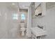 Clean, renovated bathroom features tiled shower, sink, toilet, and modern fixtures at 4400 Floramar Ter, New Port Richey, FL 34652