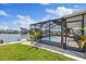Exterior view of a home with a screened-in lanai and plunge pool on a waterfront lot at 4400 Floramar Ter, New Port Richey, FL 34652