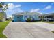 Charming blue coastal home with a welcoming front porch, carport, and well-maintained landscaping at 4400 Floramar Ter, New Port Richey, FL 34652